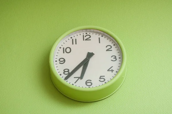 Moderne Uhr an grüner Wand — Stockfoto