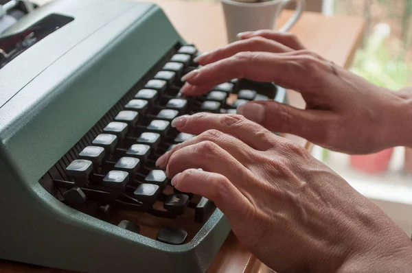 hand of woman with typewriter  and cup of coffee