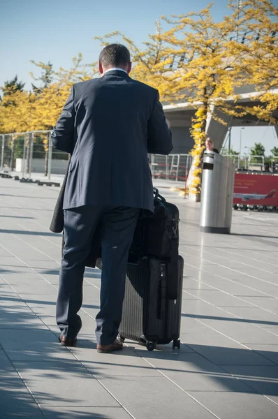 business man with a suitcase waiting for a taxi at the airport