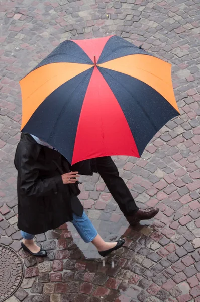 Pár s deštníkem na dláždění místo ve městě — Stock fotografie