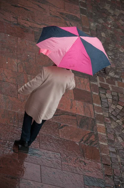Женщина с зонтиком на булыжнике место в городе — стоковое фото