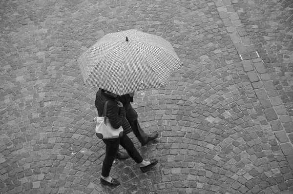 Couple  with umbrella on cobbles place in the city — Stock Photo, Image