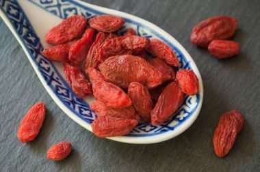  Kara tahta backgr Çinli bir kaşık Goji meyveleri