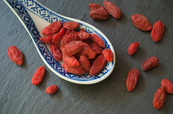 Bagas de goji em uma colher chinesa no backgr quadro — Fotografia de Stock