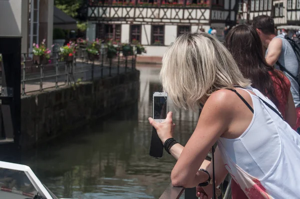 Mujer cosa una foto con el teléfono en el pequeño barrio de Francia en Estrasburgo — Foto de Stock