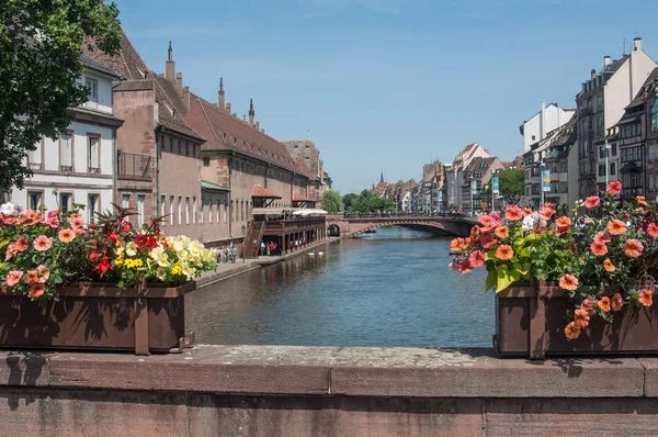 Traditionelle steinerne Brücke über den Fluss mit Blumen im kleinen Französischen Viertel in Straßburg — Stockfoto