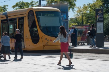 Mulhouse'deki tren istasyonu önünde yürüyen kadın