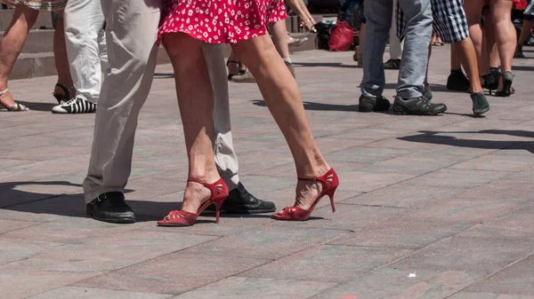 legs of couples of tango dancers on main place with o