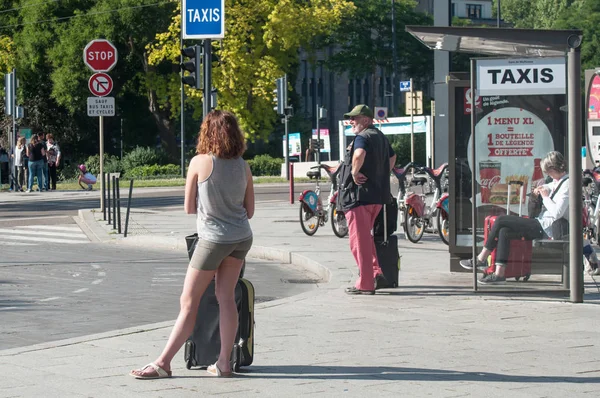 Les personnes qui attendent un véhicule à l'arrêt de taxi — Photo