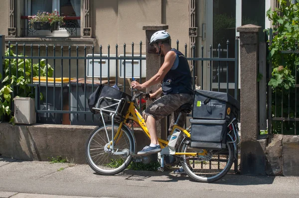 Postman with bicycle in the street — Stock Photo, Image