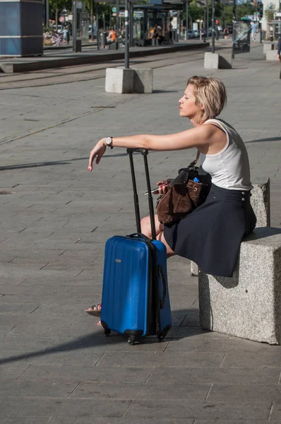 Женщина ждет с чемоданом перед вокзалом в Мюлузе — стоковое фото