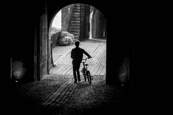 Silhueta ciclista atravessando um túnel escuro — Fotografia de Stock