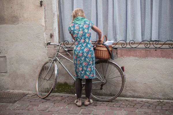 Frau mit blauem Vintage-Kleid und Fahrrad bei der Dampfpunk-Ausstellung in Kaysersberg — Stockfoto