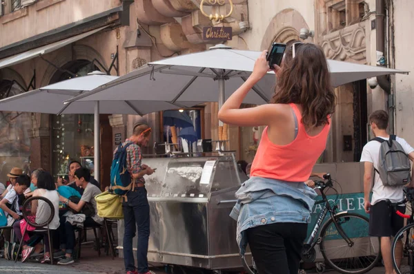 Turista tomando una foto con teléfono cerca de la catedral de Estrasburgo — Foto de Stock