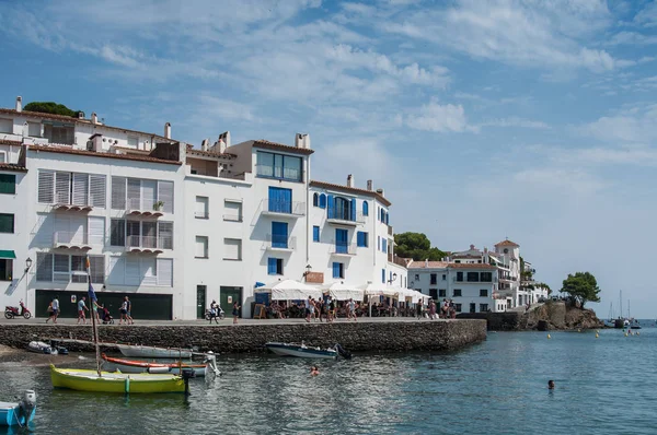 Panorama of architecture in Cadaques with terraces of restaurants and boats moored near the coast — Stock Photo, Image