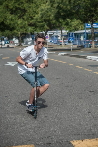 Teenager with kick scooter in the parking — Stock Photo, Image