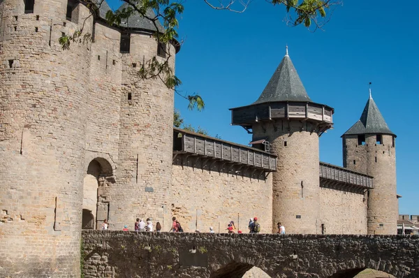 Tourists on stone bridge in fortifications entry — Stock Photo, Image