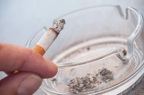 タバコと灰皿を持つ男の手 — ストック写真