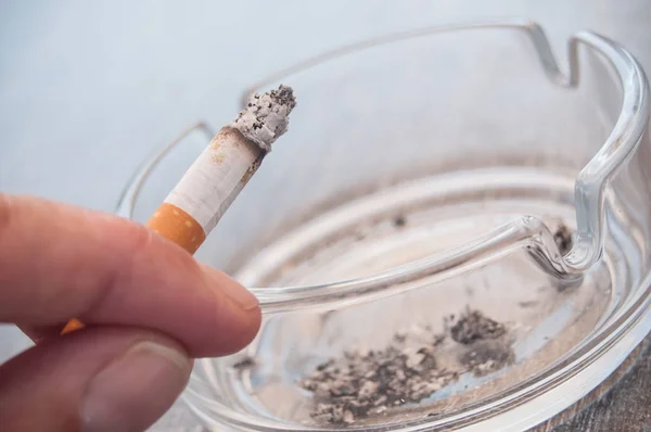 Hand of man with cigarette and ashtray — Stock Photo, Image