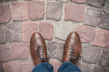 adam ayaklarda kahverengi Ayakkabı ve kot kaldırım kömür topakları