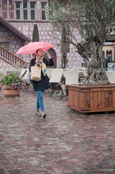 Porträt einer Frau mit Regenschirm auf Kopfsteinpflaster Platz in der Stadt — Stockfoto