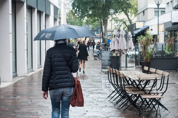 Retrato de mulher com guarda-chuva na rua de paralelepípedos com terraço restaurante vazio — Fotografia de Stock