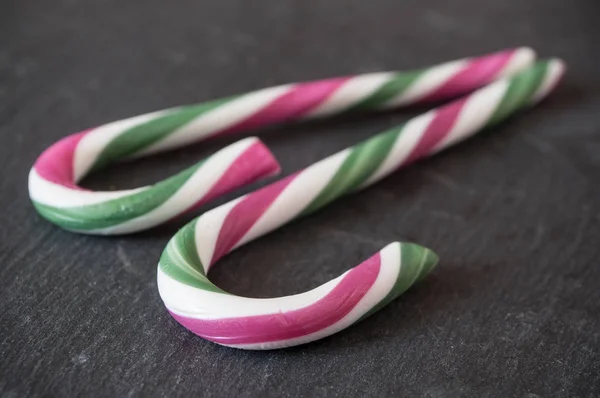 Candy canes on chalkboard background — Stock Photo, Image