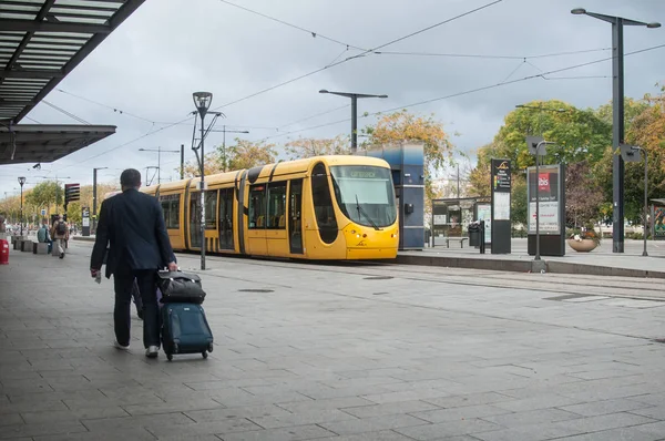 Man walking with suitcase in front of the train station — Stock Photo, Image