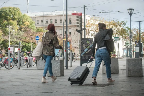 Женщин, идущих с чемоданом перед вокзалом — стоковое фото