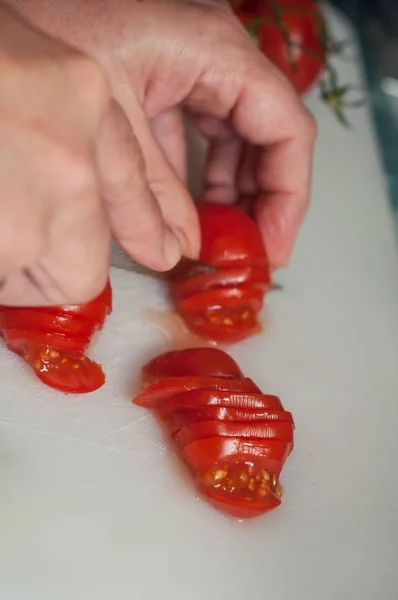 Žena ruční řezání čerstvých rajčat na plastové prkénko — Stock fotografie