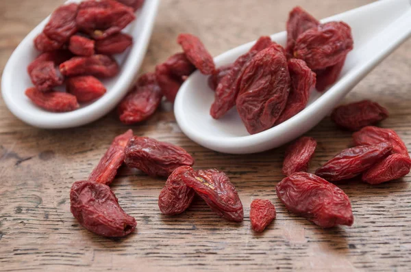 Close-up de bagas de goji em colher chinesa e frasco de vidro — Fotografia de Stock