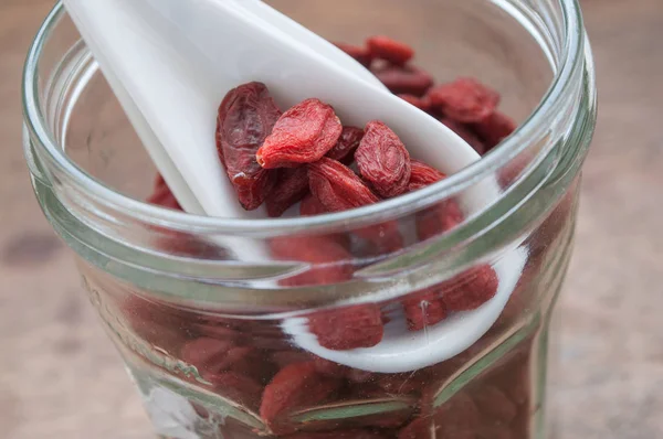 Bayas de goji en cuchara china y frasco de vidrio — Foto de Stock