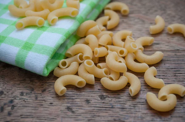 Macarrão e guardanapo verde na mesa de madeira — Fotografia de Stock