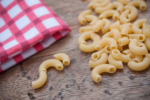 Pasta y servilleta roja sobre fondo de mesa de madera — Foto de Stock