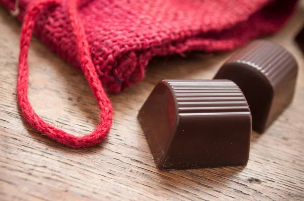 Chocolates sobre fondo de mesa de madera — Foto de Stock
