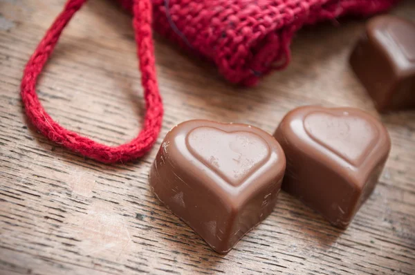 Chocolates en forma de corazón sobre fondo de mesa de madera — Foto de Stock