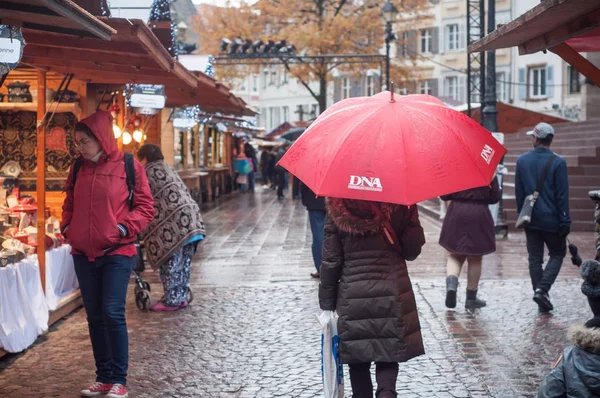 Menschen mit Regenschirm auf Weihnachtsmarkt in Mülhausen — Stockfoto