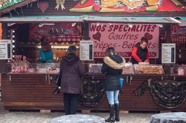 Menschen stehen auf dem Weihnachtsmarkt vor einem Pfannkuchengeschäft — Stockfoto