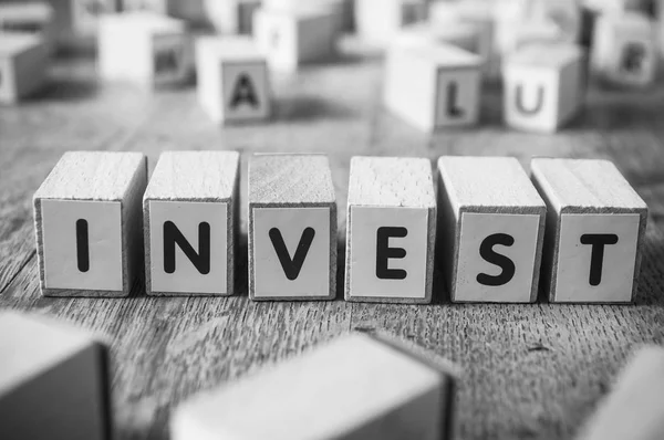 Begreppet word bildar med kub - investera — Stockfoto