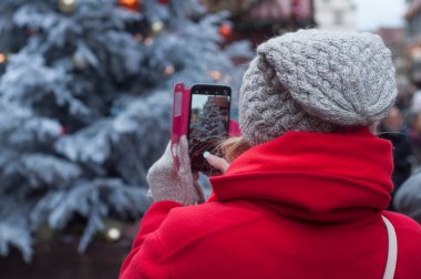 Turizm telefon ile Noel ağacı Noel piyasasında fotoğrafını yün şapka ile portresi 