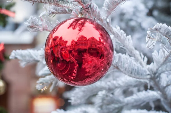 Rote Kugel im verschneiten Weihnachtsbaum auf der Straße — Stockfoto