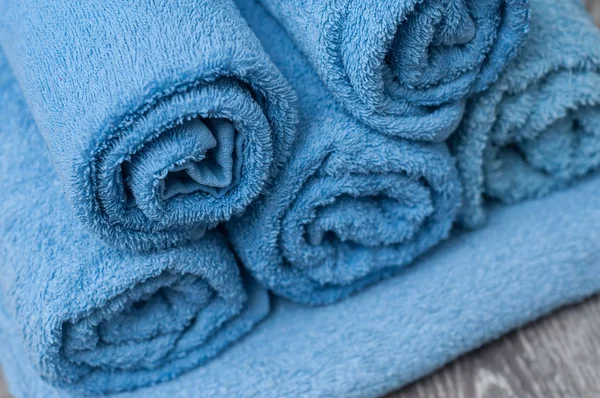 Niebieski walcowane ręczniki na drewnianym stole w łazience — Zdjęcie stockowe