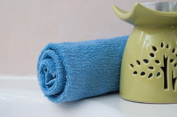 Blue rolled bath towel with candle in bathroom — Stock Photo, Image