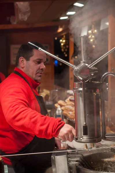 Muž obsluhující churros na vánočním trhu — Stock fotografie