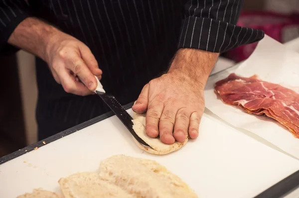 Ruka člověka řezání panini italský sendvič — Stock fotografie