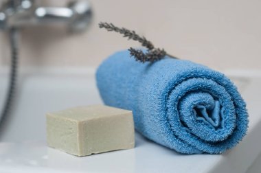 Lavanta sabun ve haddelenmiş mavi havlu banyoda