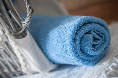  ahşap sepet içinde mavi haddelenmiş banyo havlusu