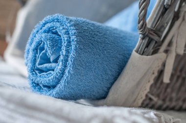  ahşap sepet içinde mavi haddelenmiş banyo havlusu