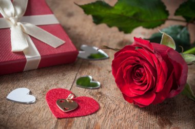 kırmızı gül ve ahşap masa arka plan üzerinde hediye