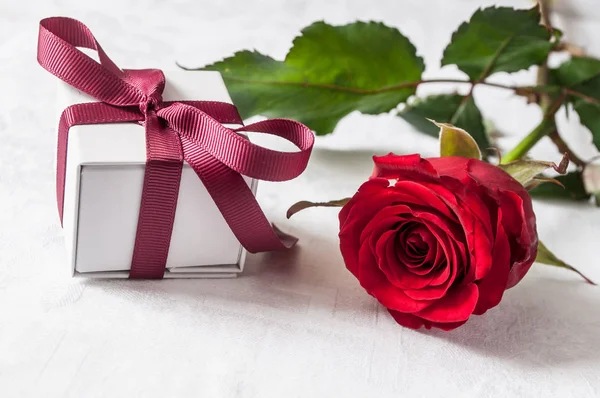 Rosa roja y regalo sobre fondo blanco — Foto de Stock